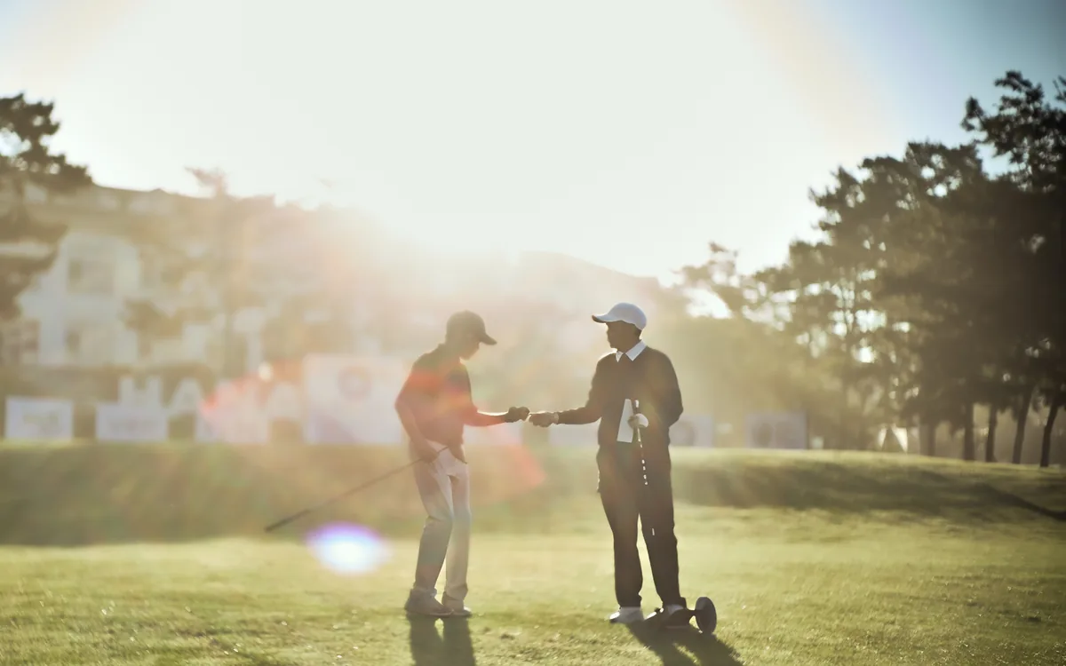 Players shaking hands at sunrise after the round