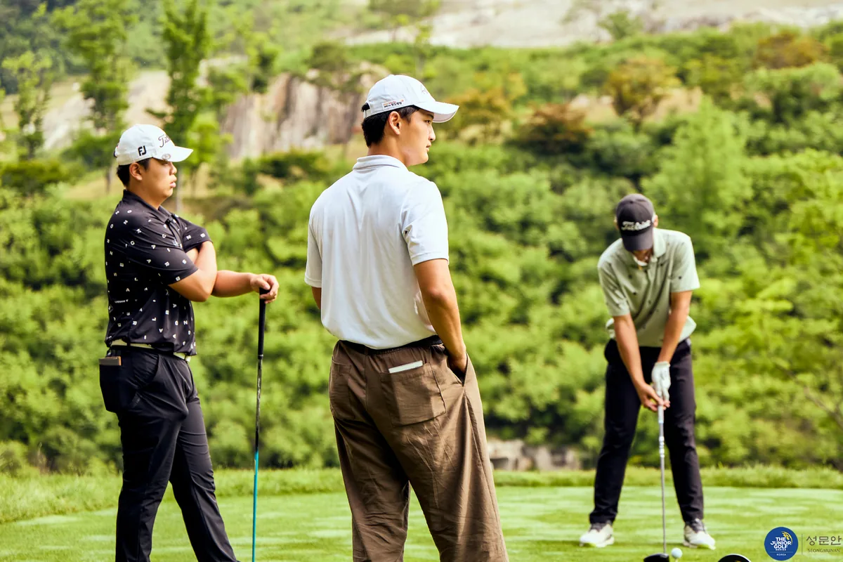 Coach reviewing play with junior golfers