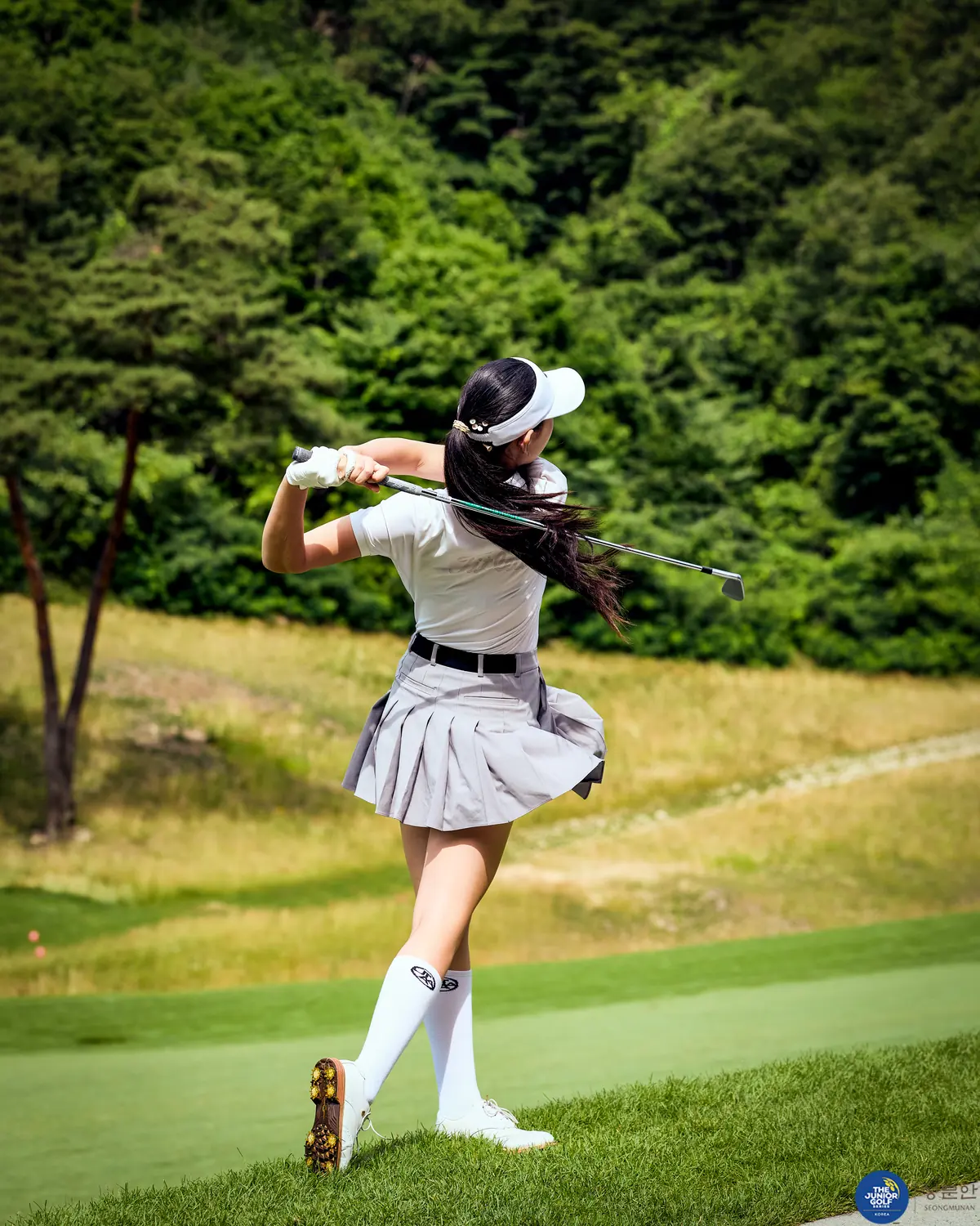 Junior golfer driving off the tee